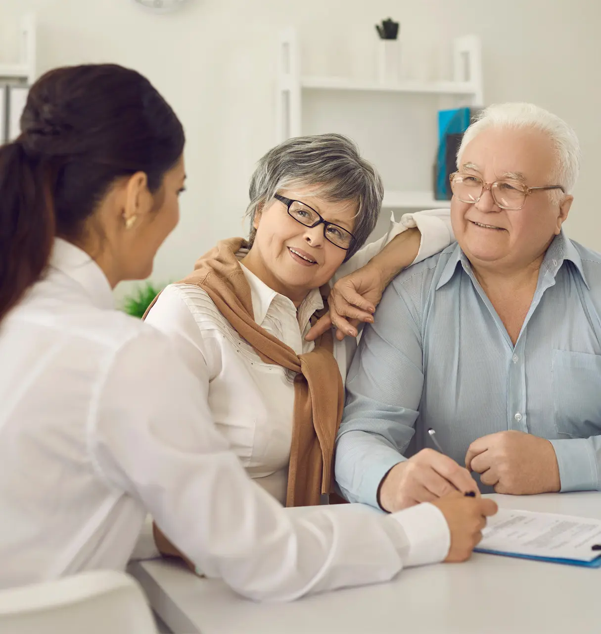 An older couple sitting a table talking to a doctor.